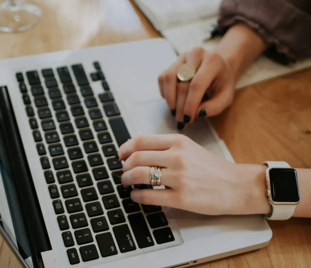 Bild av två kvinnliga händer som arbetar på en dator